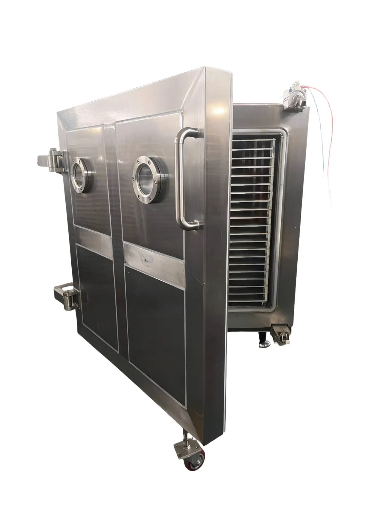 Industrial freeze dryer with open chamber and product trays, showing the batch capacity available in a single load